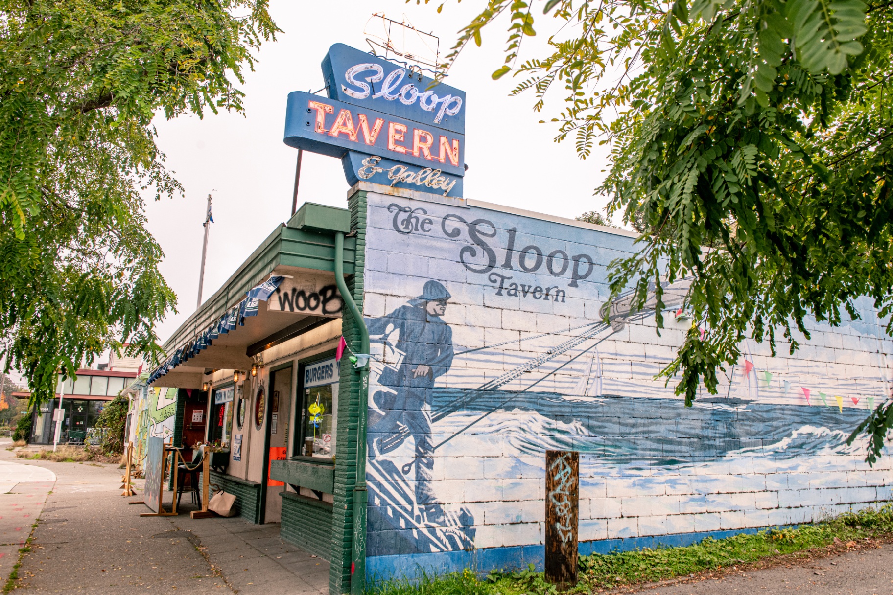 The Sloop Tavern's iconic neon sign and sailor mural on NW Market Street