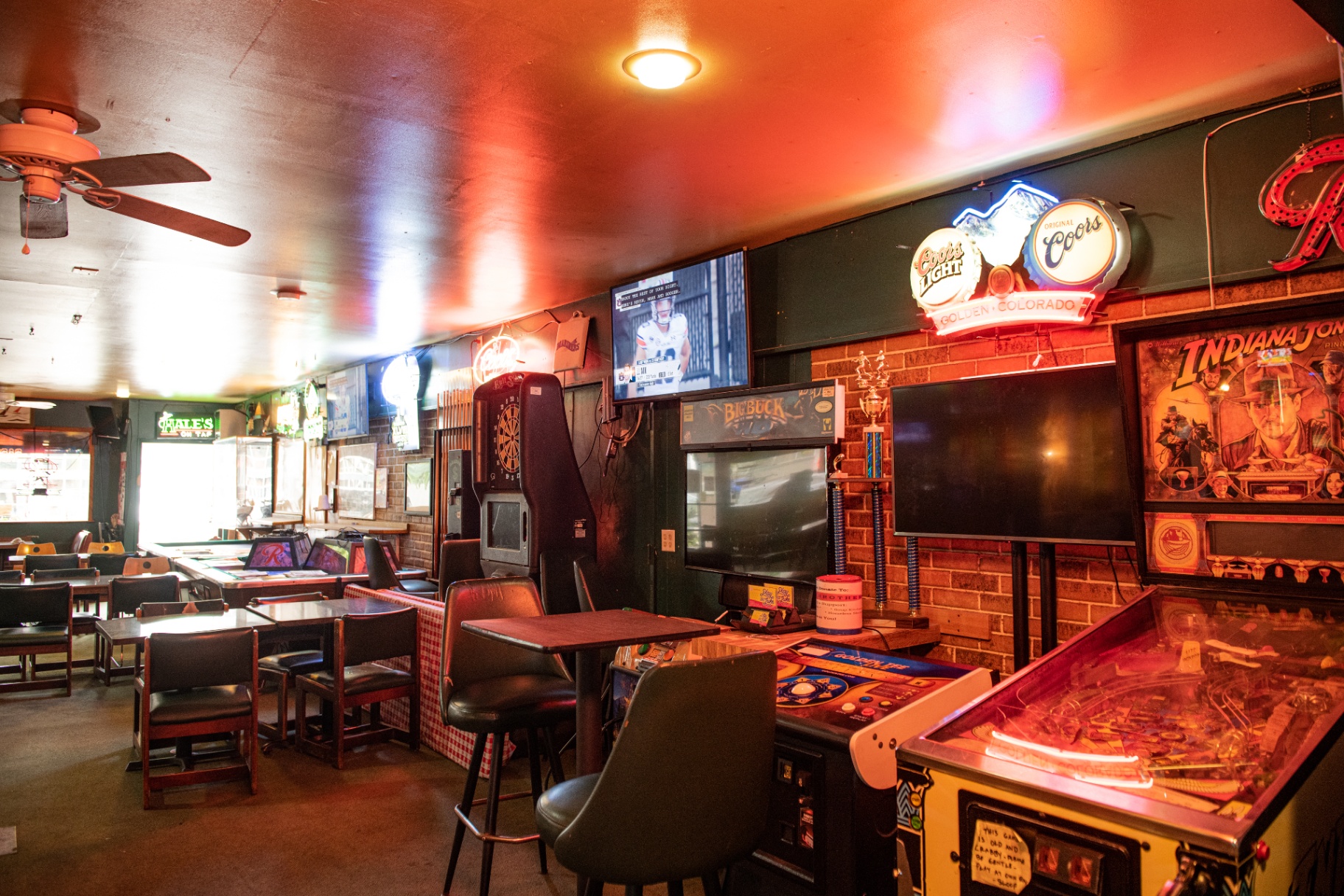 Interior with pinball, Big Buck Hunter, neon signs and red lighting